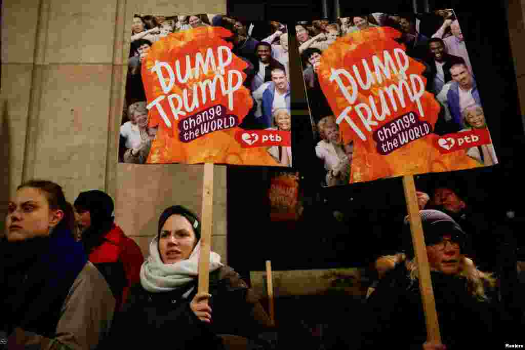 People hold signs that read "Dump Trump" during a protest, on the day of U.S. President Donald Trump's inauguration, in Brussels, Belgium, Jan. 20, 2025.