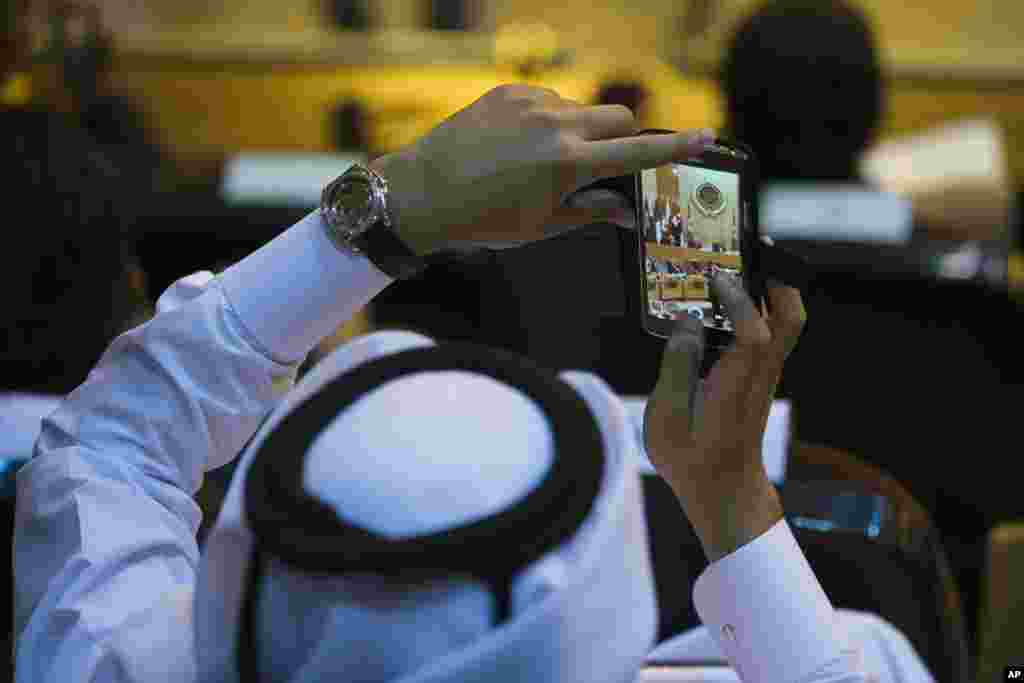 A member of the United Arab Emirates delegation uses his mobilephone to take a photo of an Arab foreign minister meeting at the Arab League headquarters in Cairo, Egypt, Sept. 7, 2014.