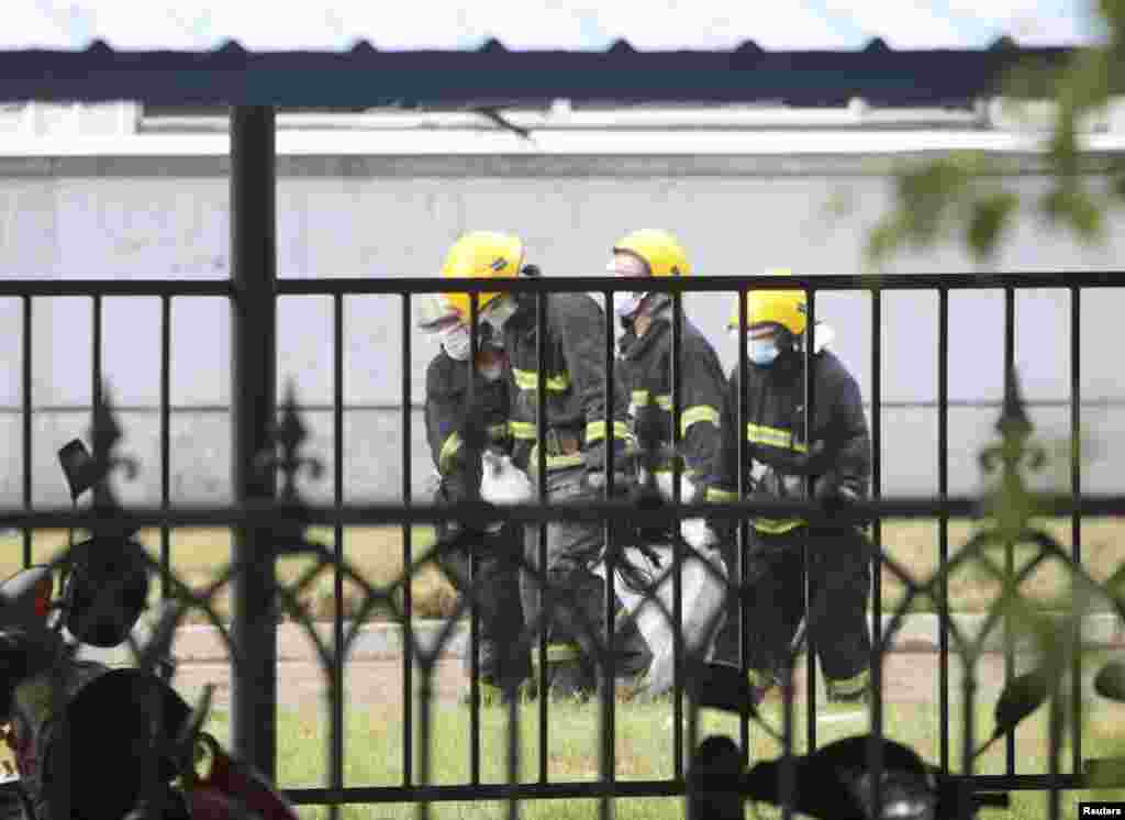 Rescue workers move the body of a victim from the site of a poultry slaughterhouse fire in Dehui, Jilin province, China, June 3, 2013. 