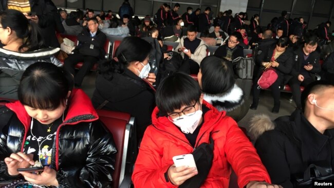 在北京西客站等候前往武汉的旅客戴着口罩在候车室里候车。（2020年1月20日）