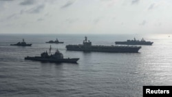 The Ronald Reagan Strike Group ships conduct a photo exercise with the Japan Maritime Self-Defense Force ships in the South China Sea, Aug. 31, 2018.
