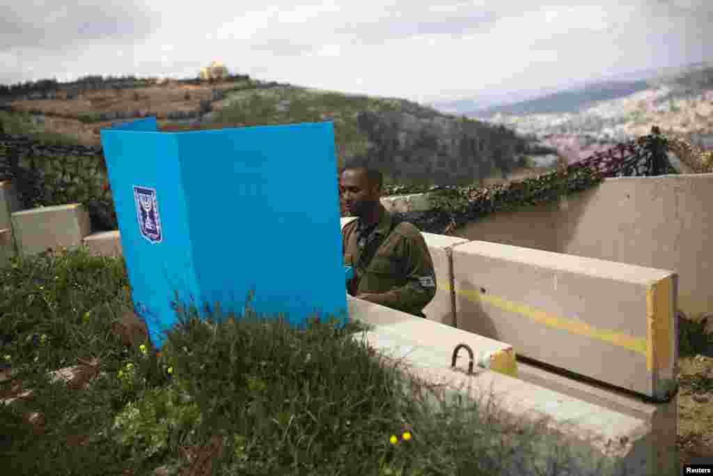An Israeli soldier casts his ballot at a mobile voting booth at an army base on Mount Gerizim, near the West Bank City of Nablus, March 17, 2015.