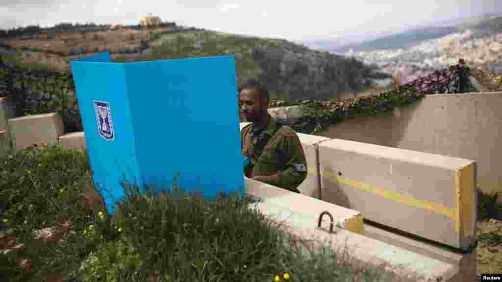 Un soldat israélien place son bulletin de votre dans l'urne pour l'élection parlementaire dans un bureau de vote mobile à la base militaire sur le mont Garizim, près de la ville de Naplouse en Cisjordanie, le 17 mars 2015.