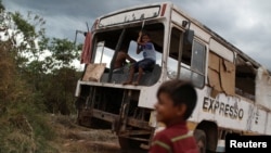 Venezuelan Erasmo Valderrama plays with a friend on an abandoned bus in the border city of Pacaraima, Brazil, April 13, 2019. 
