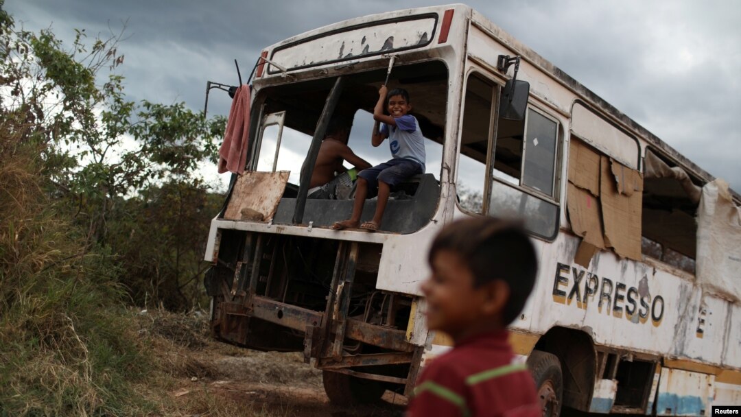 Venezuelan Erasmo Valderrama plays with a friend on an abandoned bus in the border city of Pacaraima, Brazil, April 13, 2019. 