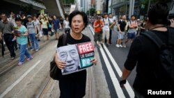 FILE - An activist holds a placard demanding the release of Chinese Nobel Peace Laureate Liu Xiaobo during a demonstration on the 20th anniversary of the territory's handover from Britain to Chinese rule, in Hong Kong, China, July 1, 2017. 