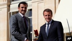 FILE: France's President Emmanuel Macron, right, greets the Emir of Qatar, Sheikh Tamim bin Hamad Al Thani, upon his arrival at the Elysee Palace in Paris, France. Taken Sept. 15, 2017.