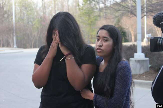 Edith Galvan, an undocumented immigrant and DACA recipient, offers support to Alisha Marcial during a vigil in honor of Marcial’s father. The father of seven U.S.-born children is detained at a county jail in Raleigh, North Carolina. (Photo: A. Barros / VOA)