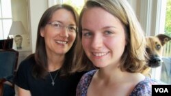 Sheila Dougherty, left, encouraged daughter Annemarie to become one of the first female altar servers in her Catholic parish in Arlington, Virginia. With them is the family dog, Maple. (C. Guensburg/VOA News) 