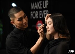 Kodo Nishimura (kiri) menunjukkan teknik merias pada model Yuri Hotta (kanan) di Universitas Waseda, Tokyo, 5 Juli 2018. (Foto:AFP)