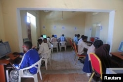 FILE - People use computers at an internet cafe in the Hodan area of Mogadishu, Oct. 9, 2013.