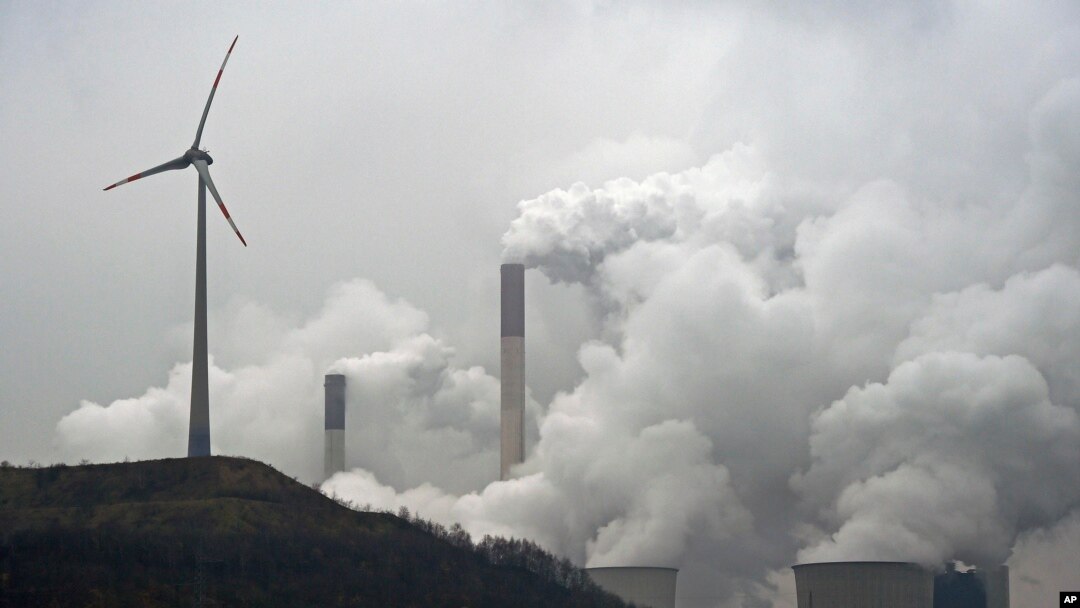 ARSIP – Foto yang diambil hari Senin, 1 Desember 2014, memperlihatkan turbin angin dengan pembangkit listrik tenaga batubara di Gelsenkirchen, Jerman (foto: (AP Photo/Martin Meissner, Arsip)