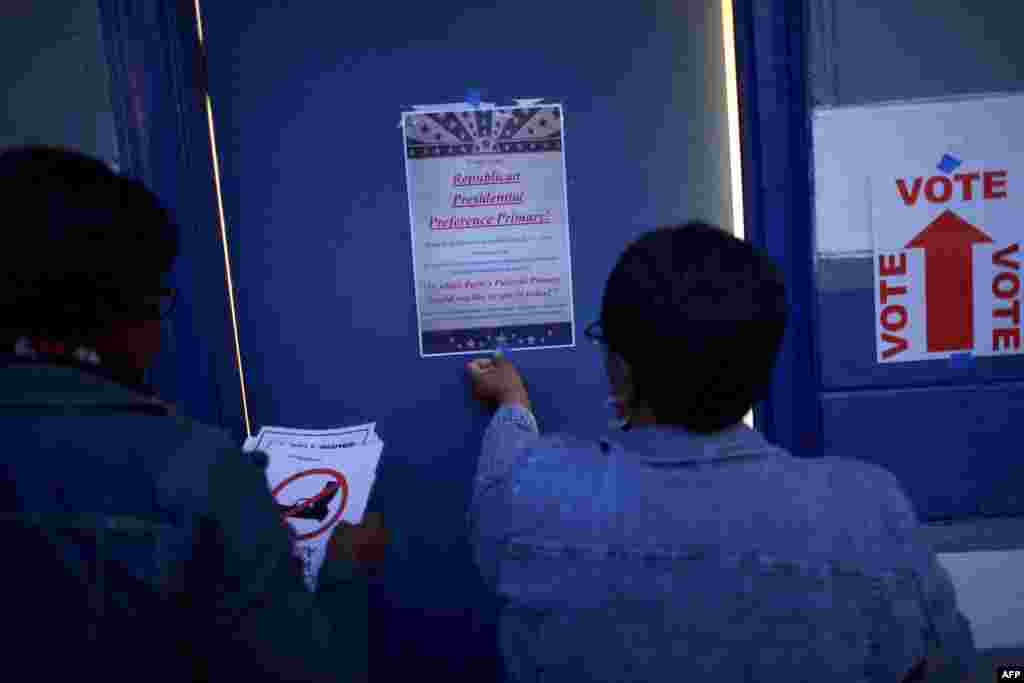 Gethsemani Community Center polling station employees tape voting notices predawn before the South Carolina Republican Presidential Primary voting commences at 7 a.m. in North Charleston, S.C., Feb. 20, 2016.