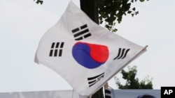 FILE - The South Korean flag flies at a protest in Seoul, South Korea, July 20, 2018. 