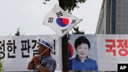 박근혜(현수막 얼굴) 전 한국 대통령 지지자가 지난 2018년 서울 광화문 광장에서 '국정농단' 재판 항의 시위를 벌이고 있다. (자료사진)