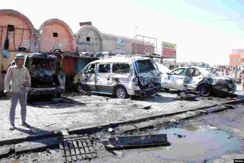 A man stands at the site of a car bomb attack in the city of Kut, southeast of Baghdad, July 29, 2013.&nbsp;