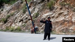 A police officer guards a check post on the outskirts of Gilgit September 19, 2012. With a few hundred hard-core cadres, the highly secretive Sunni Muslim extremist group Lashkar-e-Jhangvi, or LeJ, aims to trigger tit-for tat sectarian violence.
