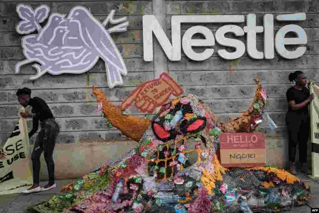 Aktivis kelompok lingkungan Greenpeace Afrika memrotes perusahaan makanan raksasa Swiss &quot;Nestle&quot; atas kemasan plastik sekali pakainya, di sebelah &#39;monster plastik&#39; yang dibuat dengan kemasan plastik Nestle, pada aksi di pabrik Nestle di Nairobi, Kenya. 