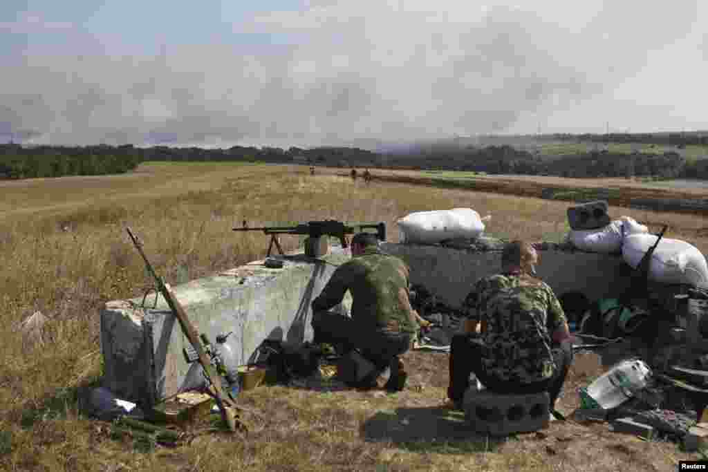 Ukrainian servicemen check their weapons as they guard at a checkpoint near the town of Debaltseve in Donetsk region, Aug. 2, 2014. 