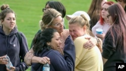 Students are comforted as they wait to be reunited with their parents following a shooting at Saugus High School that killed two and injured several people, Thursday, Nov. 14, 2019, in Santa Clarita, Calif. (AP Photo/Ringo H.W. Chiu)