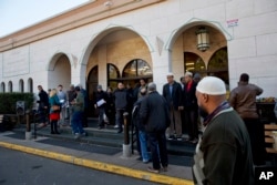 FILE - people arrive for Friday prayers at Dar al-Hijrah Mosque in Falls Church, Va. .