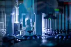 Vials of coronavirus disease (COVID-19) vaccine candidate BNT162b2 are inspected at a Pfizer manufacturing site in Kalamazoo, Michigan, U.S. in an undated photograph. (Pfizer/Handout via REUTERS)