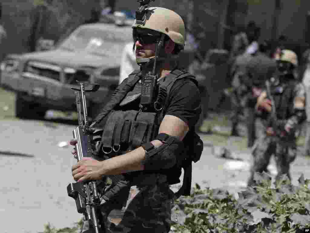 Afghan security forces stand guard at the site of a blast in Kabul, June, 18, 2013. 