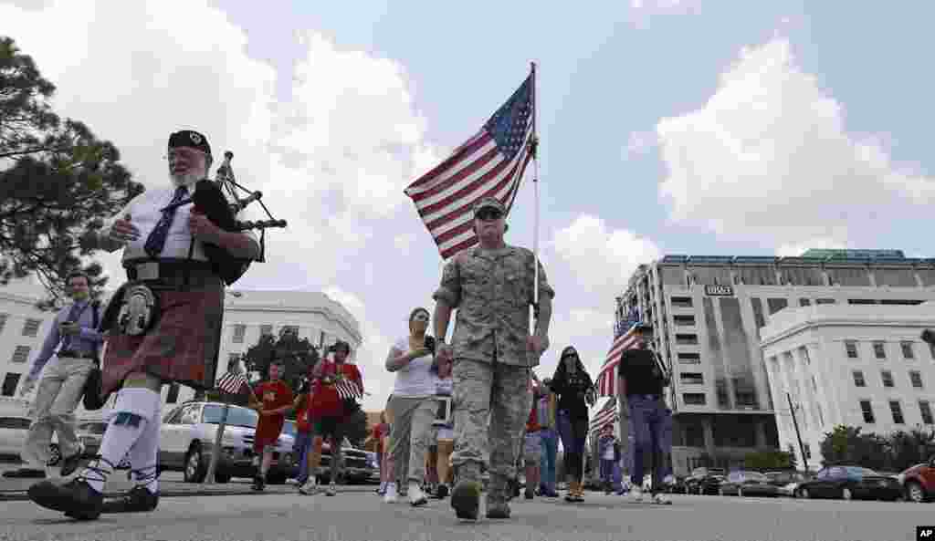 U.S. Marine Corps veteran Mac McQuown, center, of Ocala, Florida, walks up Dexter Avenue to the historic Capitol in Montgomery, Alabama. McQuown is gearing up to walk across the country. The 50-year-old Marine is walking 15,000 miles to benefit homeless veterans and military families. 