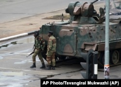 FILE: A military tank is seen with armed soldiers on the road leading to President Robert Mugabe's office in Harare, Zimbabwe Wednesday, Nov. 15, 2017