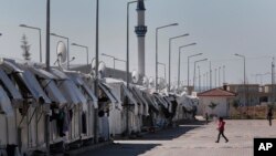 2016年3月17日叙利亚难民在为他们设置的难民营附近走动。