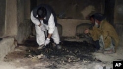 Afghan men investigate at the site of a shooting incident, apparently by a lone U.S. Army sergeant that killed 16 civilians on Sunday, in Kandahar province, March 11, 2012. 