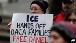 A protester holds a sign that reads "ICE Hands Off DACA Families Free Daniel," during a demonstration in front of the federal courthouse in Seattle, Feb. 17, 2017.