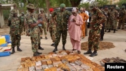 FILE - Military officials stand near ammunition seized from suspected members of Hezbollah after a raid of a building in Nigeria's northern city of Kano on May 30, 2013.