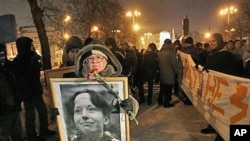 A demonstrator holds a portrait of slain reporter Anastasiya Baburova during a memorial rally in downtown Moscow, held in memory of rights lawyer Stanislav Markelov and Baburova, who were shot in broad daylight on a street near the Kremlin two years ago, 