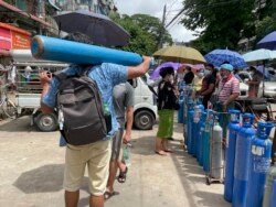Suasana di luar stasiun pengisian oksigen di kota Pazundaung, Yangon, Myanmar, Minggu, 11 Juli 2021. (AP)