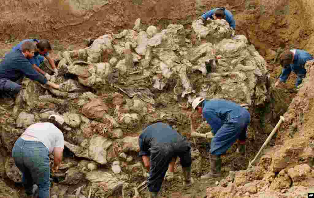 International War Crimes Tribunal investigators clear away soil and debris from dozens of Srebrenica victims buried in a mass grave near the village of Pilica, some 55 kms (32 miles) north east of Tuzla. (File 2006)