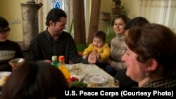 A family in Georgia shares a meal with a U.S. education volunteer.