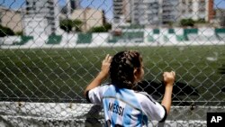 FILE - Candelabra Villegas, 12-year-old, poses for a photo wearing Lionel Messi's national team jersey, in Buenos Aires, Argentina, Jan. 31, 2019.