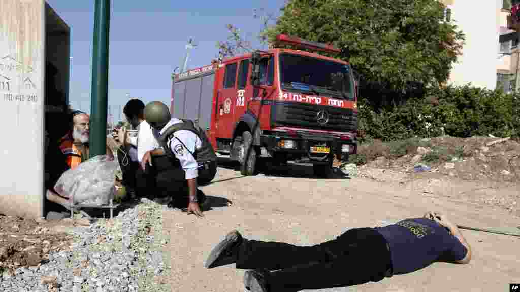 Israelis take cover as a siren warning of an incoming rocket sounds in Kiryat Malachi, southern Israel, Thursday, November 15, 2012.