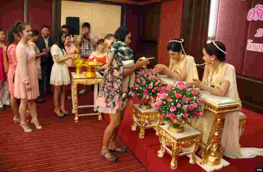 Family and guests line up to pour water on brides' hands at the ceremony in Bangkok. (Daniel Schearf/VOA)