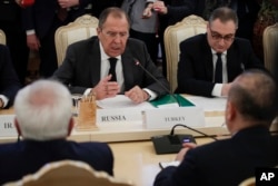 Arhiva - Ruski ministar inostranih poslova Sergej Lavrov, u sredini, gestikulira tokom razgovora sa turskim ministrom inostranih poslova Melvutom Čavašogrluom (desno, okrenut leđima) i iranskim ministrom spoljnih poslova Muhamedom Džavadom Zarifom (levo, okrenut leđima) u Moskvi, u Rusiji