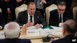 Russian Foreign Minister Sergey Lavrov, center, gestures while speaking to Turkey's Foreign Minister Mevlut Cavusoglu, right, back to a camera, and Iranian Foreign Minister Mohammad Javad Zarif, left, back to a camera, during their talks in Moscow, Russia, Dec. 20, 2016. 