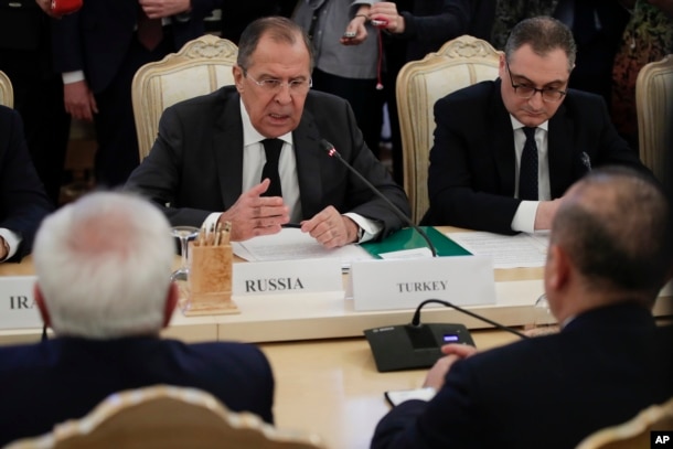 FILE - Russian Foreign Minister Sergey Lavrov, center, gestures while speaking to Turkey's Foreign Minister Mevlut Cavusoglu, right, back to a camera, and Iranian Foreign Minister Mohammad Javad Zarif, left, back to a camera, during their talks in Moscow, Russia.