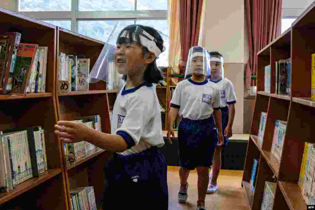 Students wearing face shields visit the library in Kinugawa Elementary School in Nikko, Tochigi Prefecture, Japan.