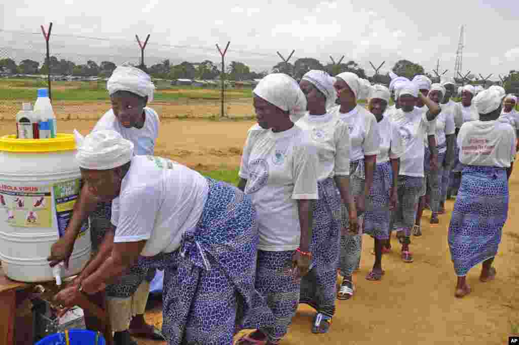 Women from different religious groups wash their hands after praying to prevent the spread of the Ebola virus, in Monrovia, Liberia, Aug. 2, 2014. 