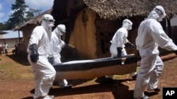 Health workers carry the body of a woman suspected of contracting the Ebola virus in Bomi county situated on the outskirts of Monrovia, Liberia, Monday, Oct. 20, 2014. Liberian President Ellen Johnson Sirleaf said Ebola has killed more than 2,000 people 