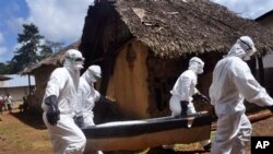 Health workers carry the body of a woman suspected of contracting the Ebola virus in Bomi county situated on the outskirts of Monrovia, Liberia, Monday, Oct. 20, 2014. Liberian President Ellen Johnson Sirleaf said Ebola has killed more than 2,000 people 