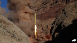 In this photo obtained from the Iranian Fars News Agency, a Qadr H long-range ballistic surface-to-surface missile is fired by Iran's powerful Revolutionary Guard, during a maneuver, in an undisclosed location in Iran, Wednesday, March 9, 2016.