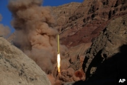 In this photo from the Iranian Fars News Agency, a Qadr H long-range ballistic surface-to-surface missile is fired by Iran's powerful Revolutionary Guard, during a maneuver, in an undisclosed location in Iran, March 9, 2016.