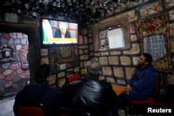 Palestinians watch a televised broadcast of Palestinian President Mahmoud Abbas' speech, in the West Bank city of Nablus, Dec. 6, 2017.